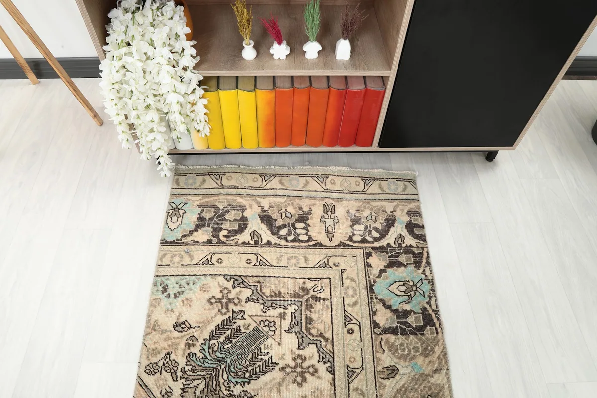 Top-down angled view of one end of the runner rug, showing its border and motifs