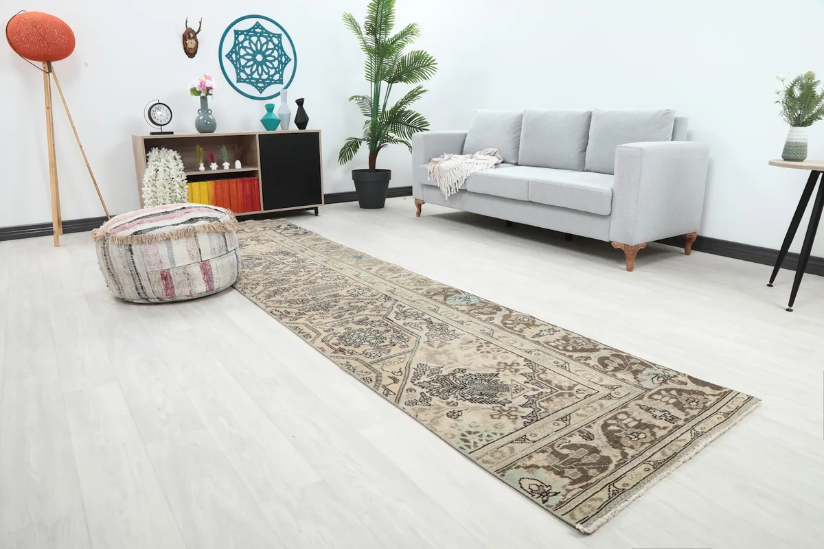 Angled view of the runner rug extending across a room with a sofa and ottoman