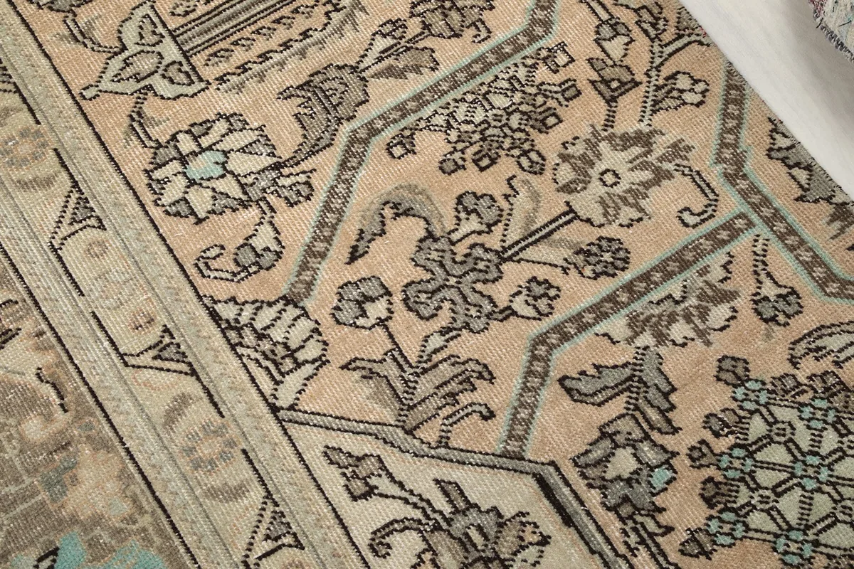 Close-up of the intricate hand-knotted motifs and color variations on the rug