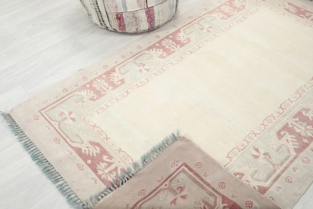 Rug partially folded to reveal the thickness and texture of the hand-knotted wool pile