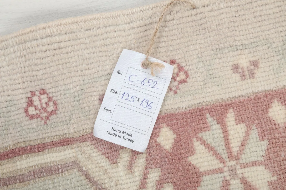 Close-up of the rug with a size tag displaying 125 x 196 cm, confirming its origin