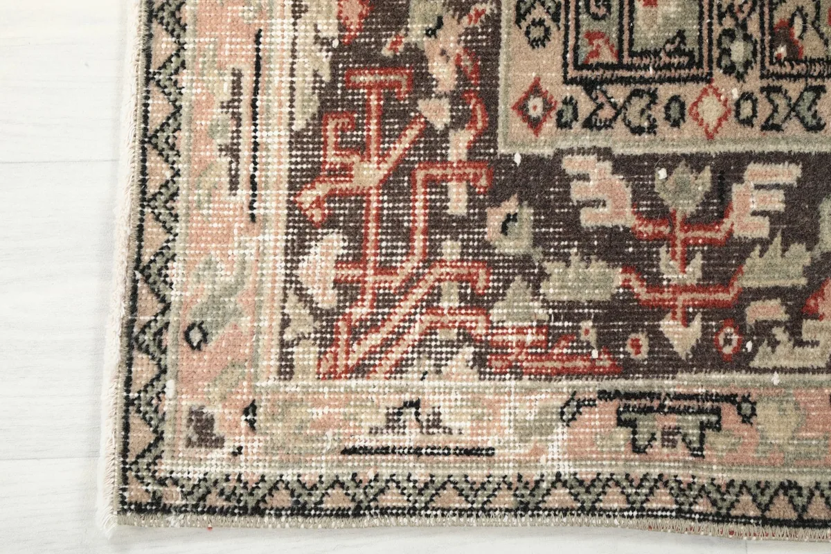 Corner detail of the rug's border, showing hand-knotted texture and fringe.