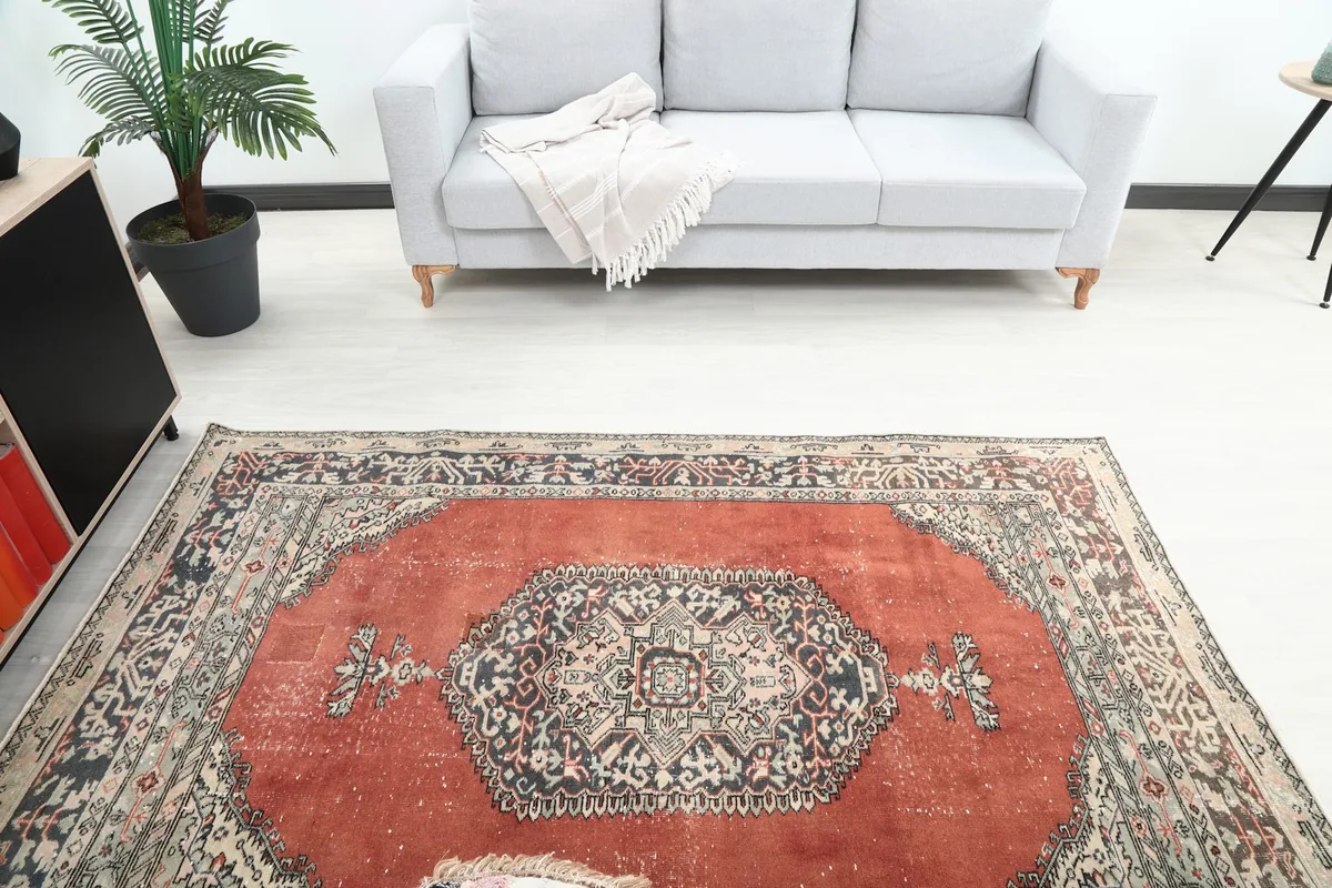 Overhead view of the vintage rug showcasing its central medallion and full pattern in a room.