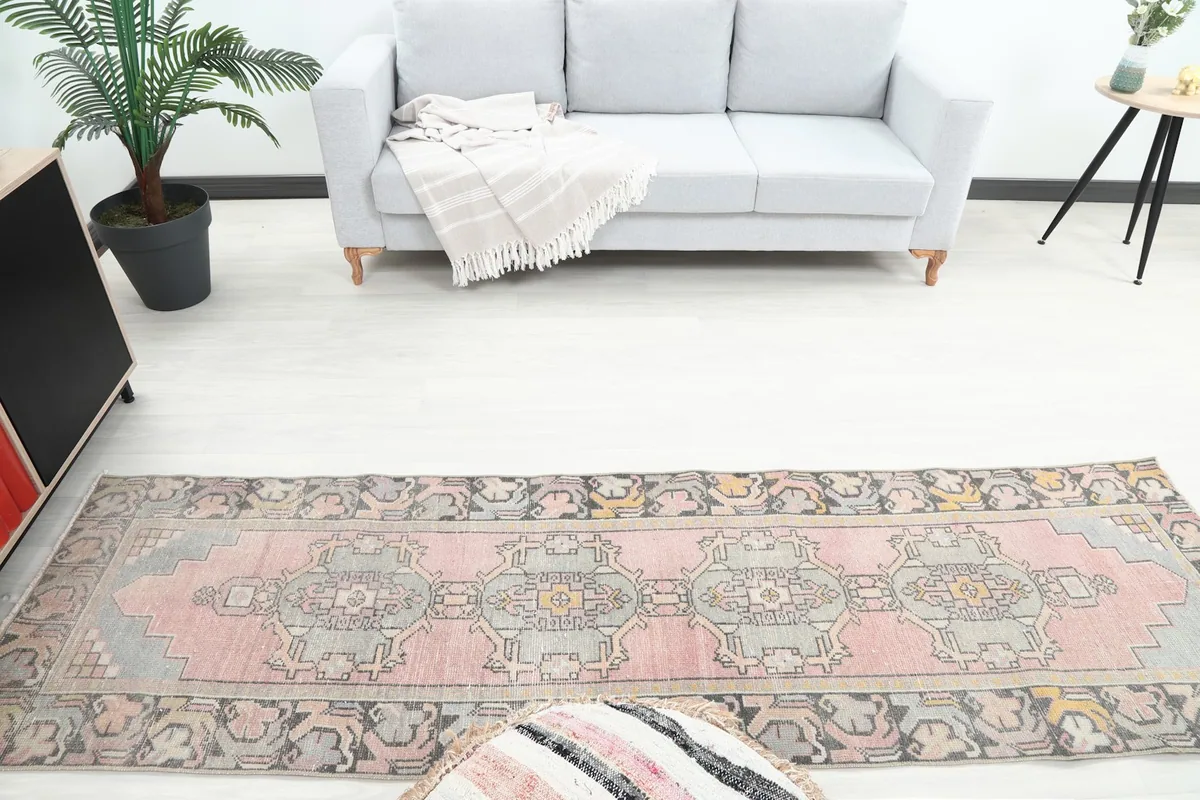 Overhead view of the pink and gray runner rug in a room, showing its full length from a higher perspective.