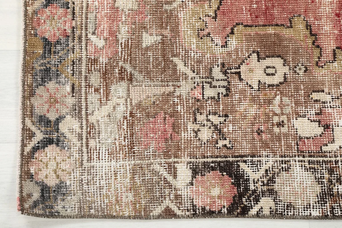 Detail of the rug's border, featuring a black background with small floral and geometric motifs