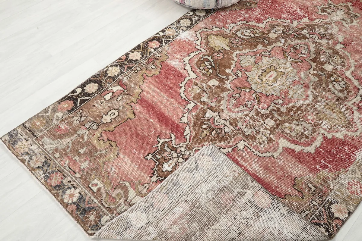 Corner of the rug folded back to show the cotton foundation and reverse side