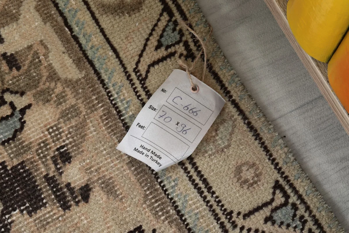 Tag attached to the rug, showing its size 70x96 cm and 'Hand Made in Turkey'