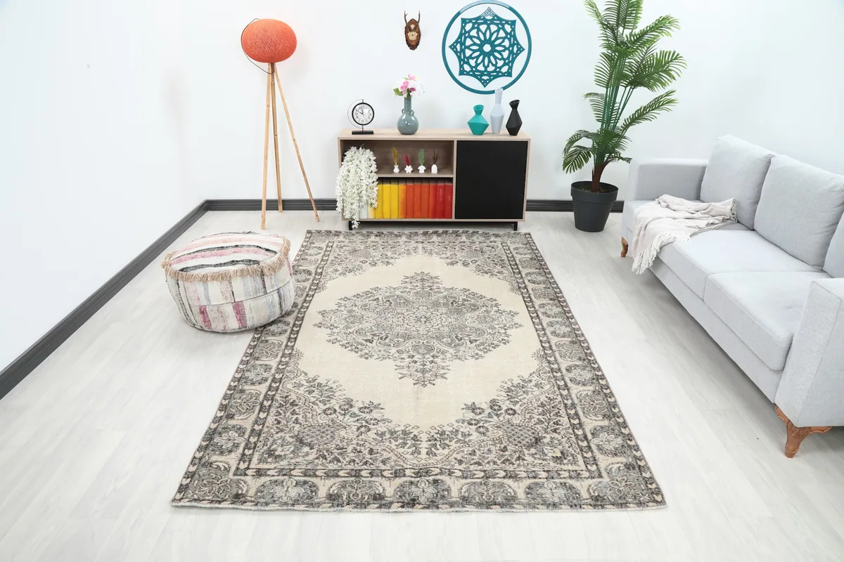 Ivory and gray vintage rug in a living room setting with a light gray sofa and modern decor