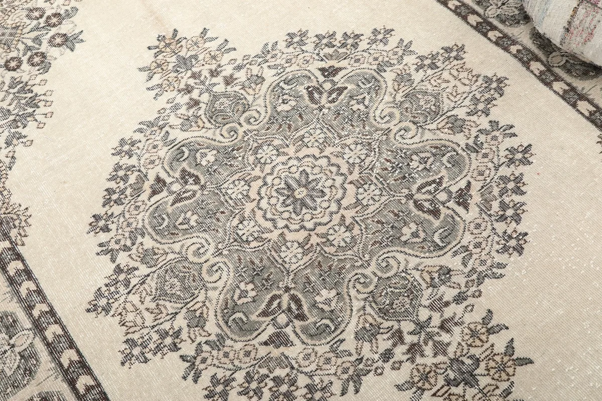 Close-up of the central medallion and surrounding floral details, showing the hand-knotted texture