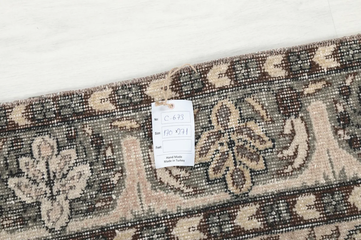 Close-up of the rug's reverse side with a tag indicating its origin and hand-made quality
