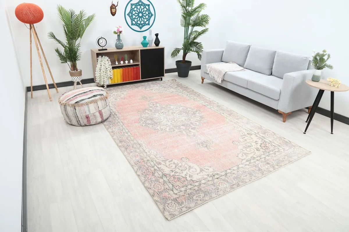 Overhead angle of the rose and gray vintage rug in a living room, showing its large size and placement.