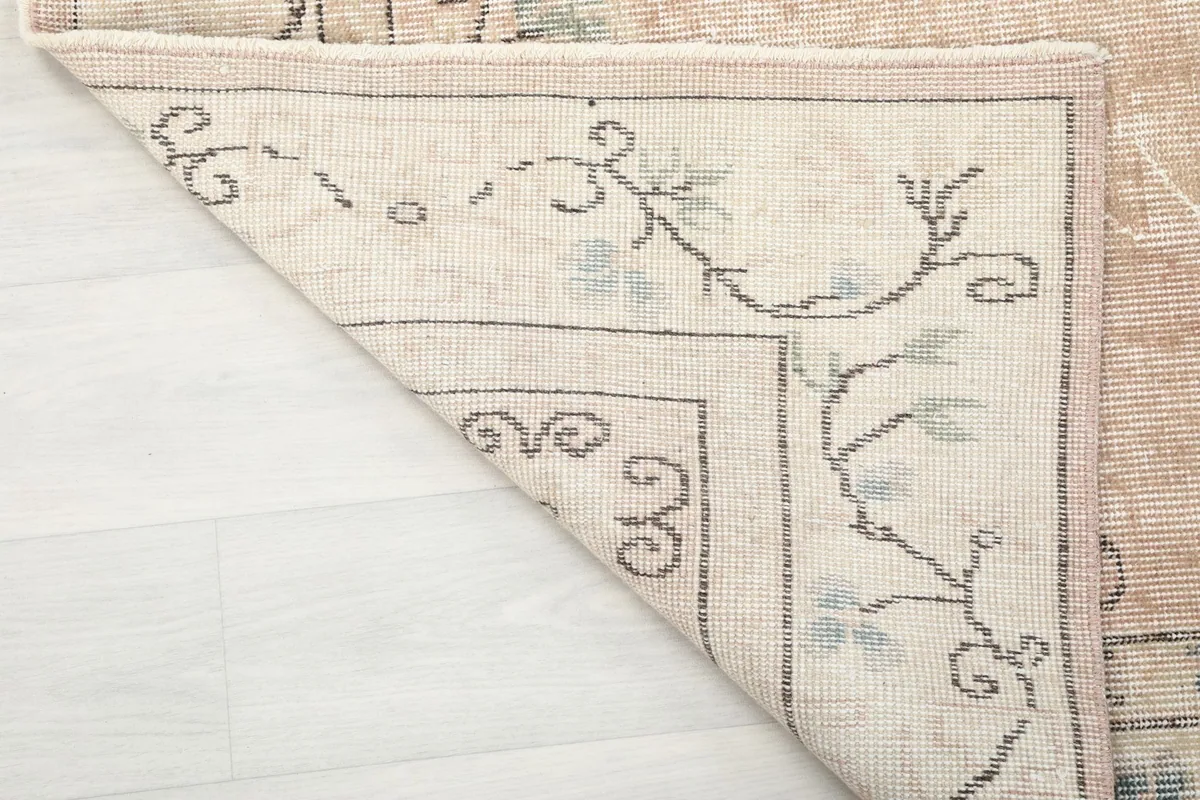 Detail of the rug's back and corner, showing the hand-knotted cotton foundation and wool pile.