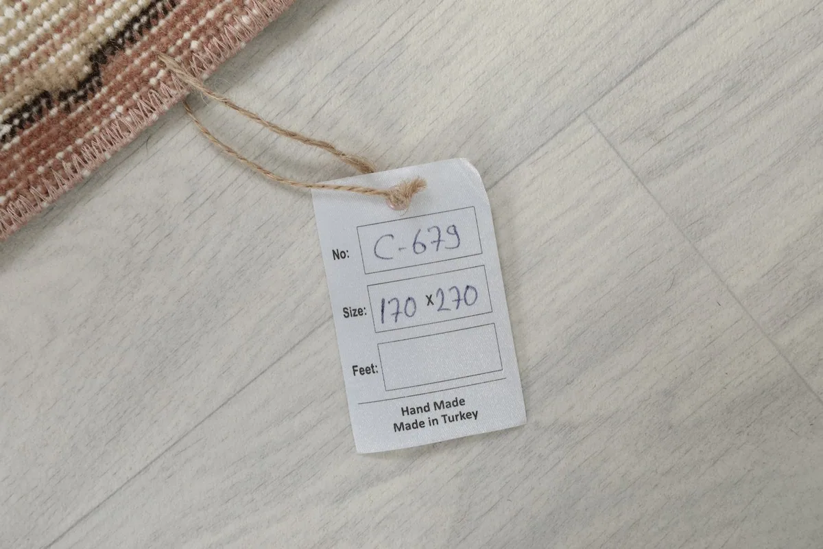 Close-up of the product tag attached to the rug, displaying model number and size in centimeters.