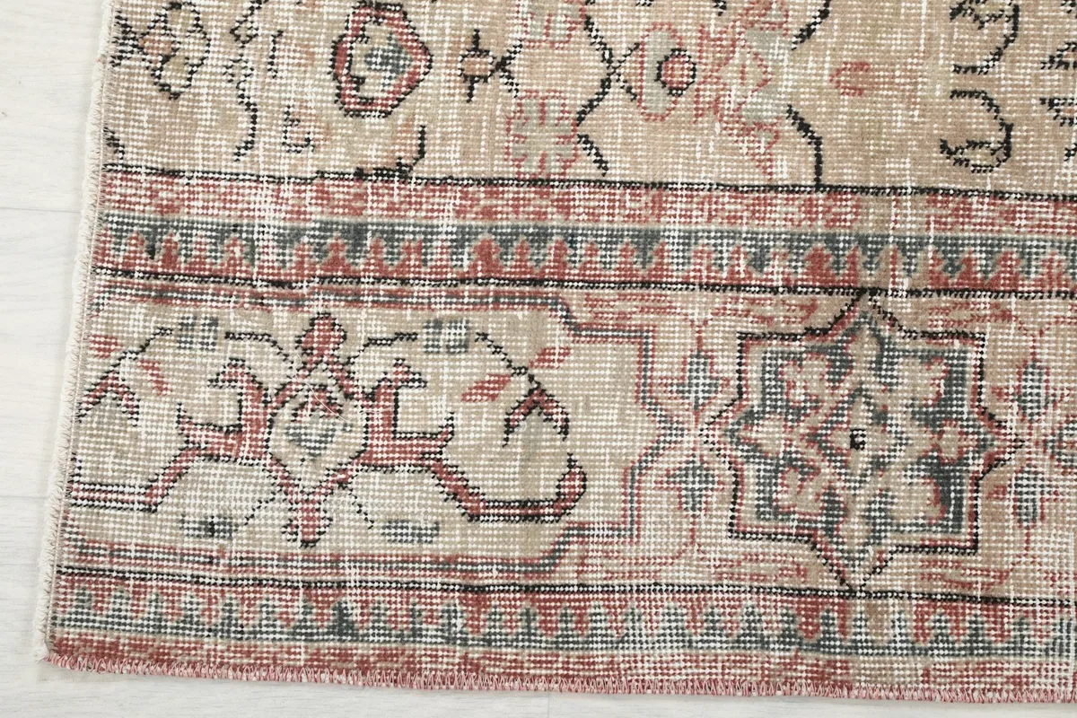 Close-up of the rug's rust and charcoal border design with small olive accents