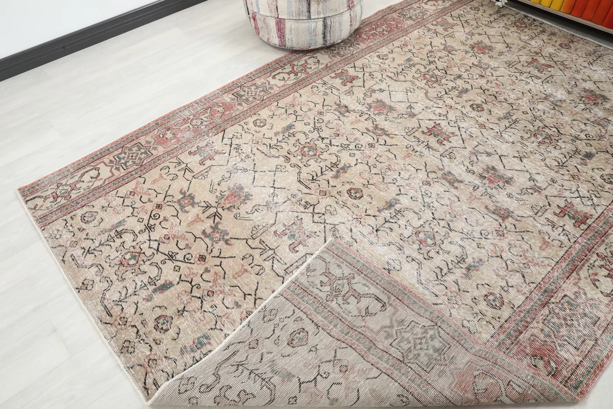 Corner of the vintage rug folded back to show the cotton foundation and reverse side