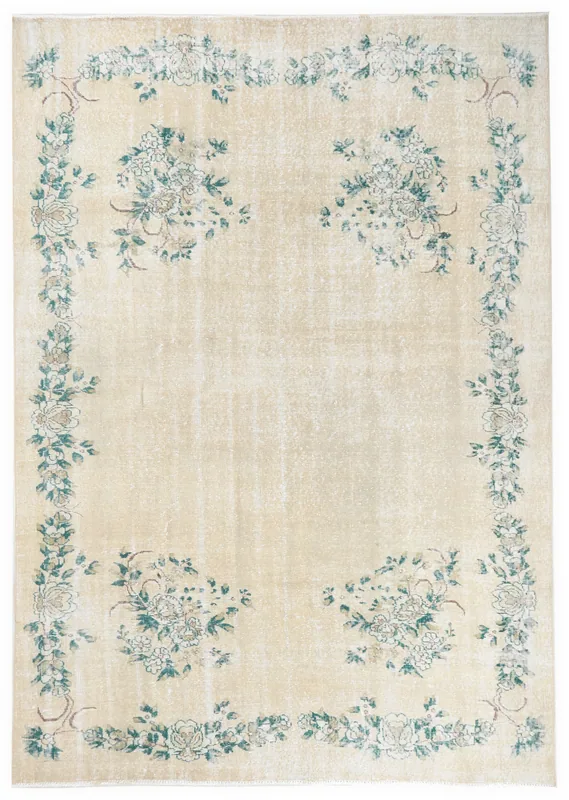Full overhead view of the vintage Anatolian rug with an ivory field and green floral patterns.