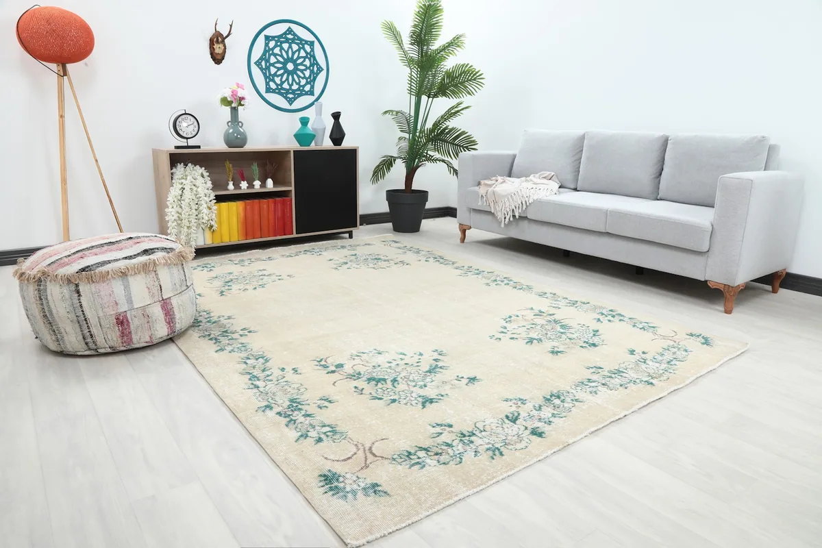Angle view of the ivory and green floral rug in a modern living space with light-colored furniture.