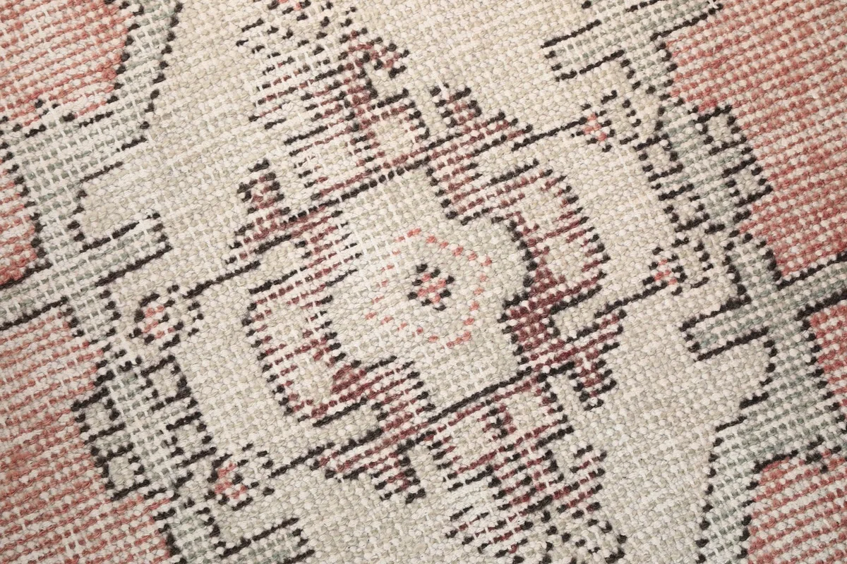 Macro detail of the hand-knotted wool pile and intricate tribal design