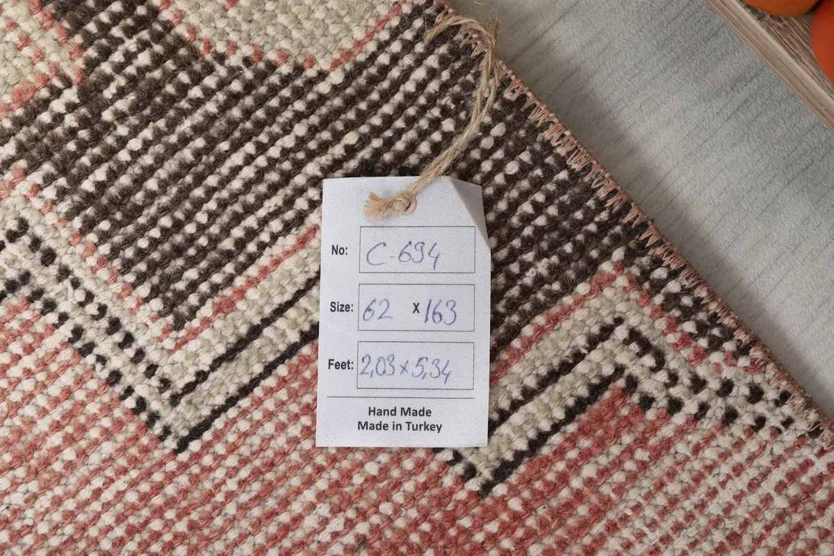 Tag showing the rug's dimensions in centimeters and feet, confirming its origin and handmade quality