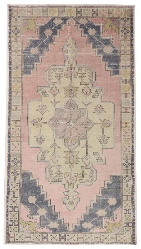 Full top view of the vintage pink and navy Anatolian area rug on a white background.