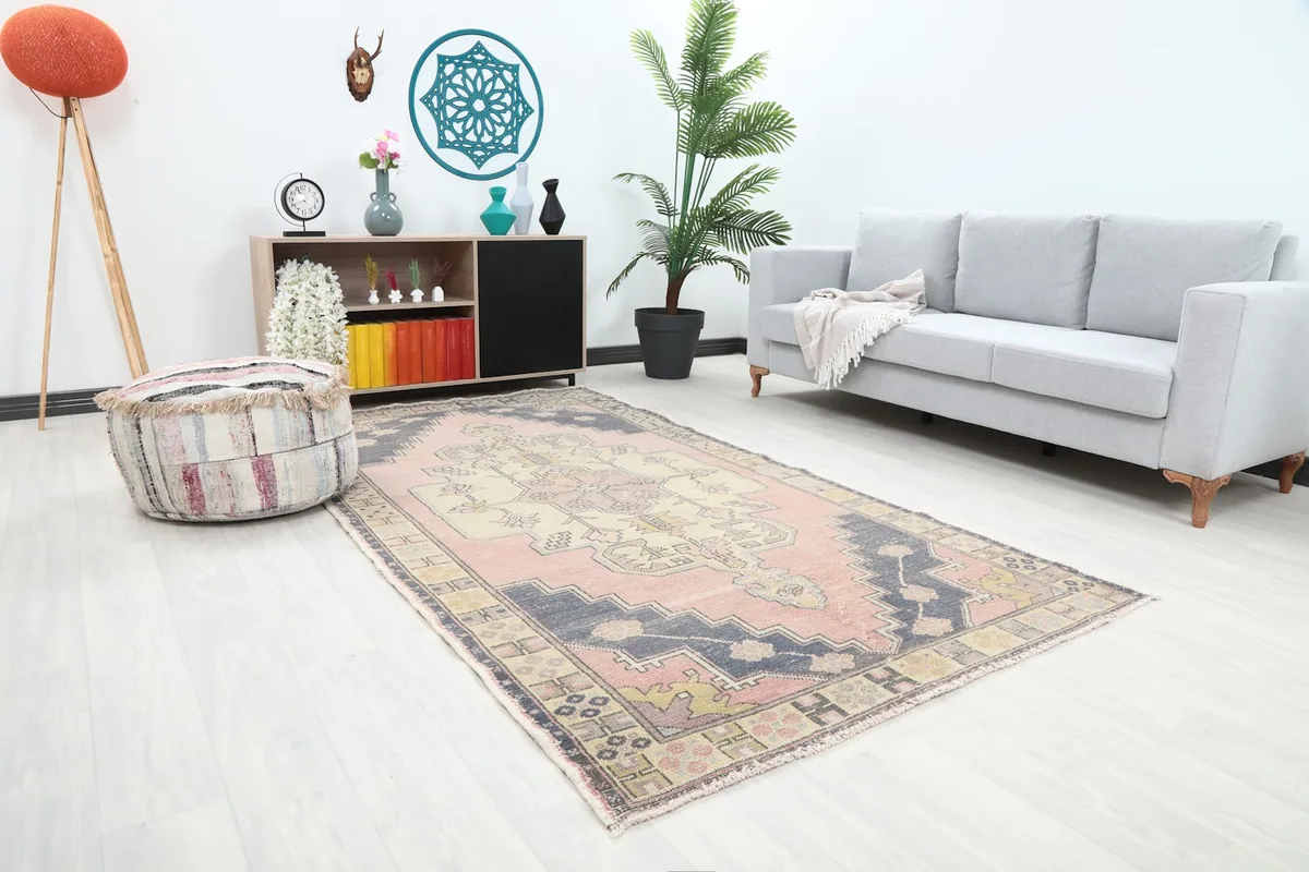 Angled view of the vintage rug in a living room, highlighting its placement and colors.