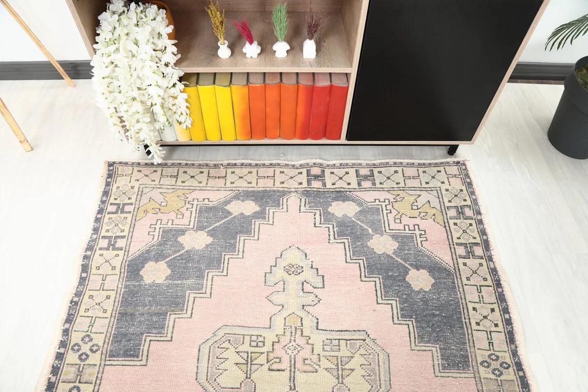 View of the rug's top end in a room, showcasing the border and upper patterns.