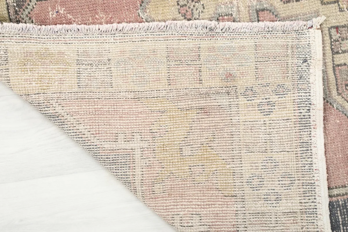 Close-up of the rug's reverse side, showing the cotton foundation and knotting detail.