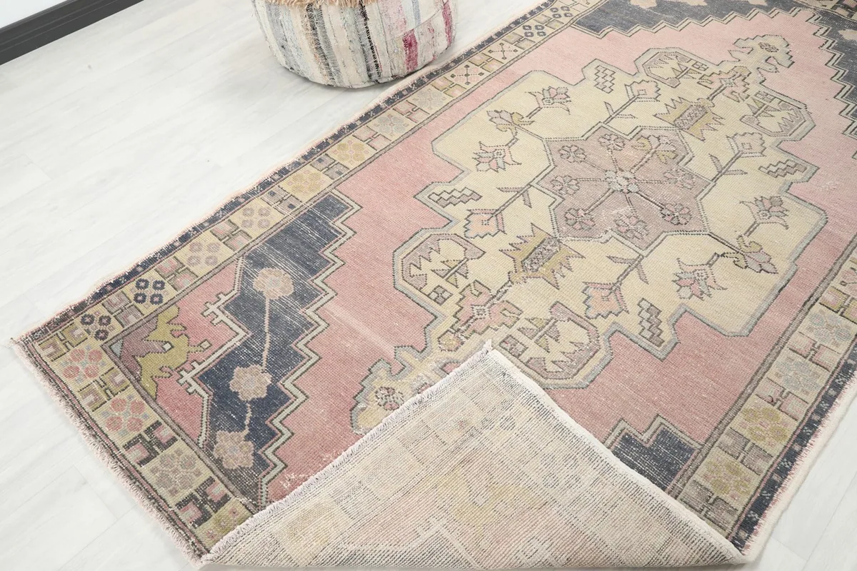 Angled view showing a folded corner of the rug, revealing the back of the hand-knotted foundation.