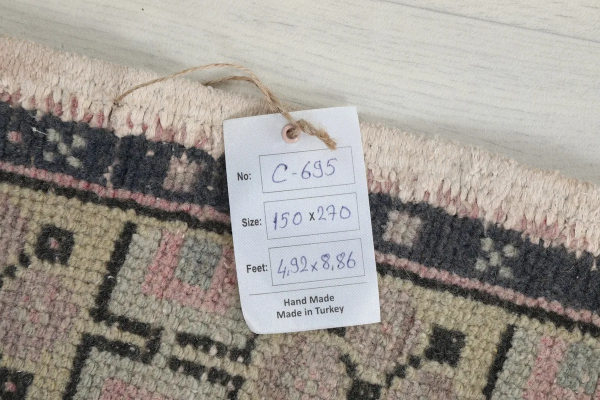Detail of the product tag attached to the rug, displaying its size and origin.