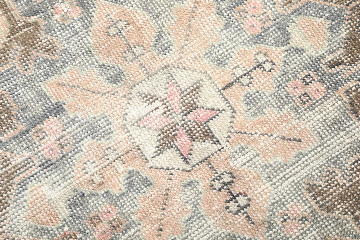 Close-up of the hand-knotted wool pile, showing texture and softened vintage colors.