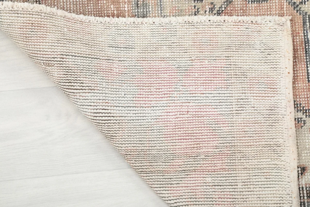 Close-up of the rug's back, revealing the hand-knotted cotton foundation.