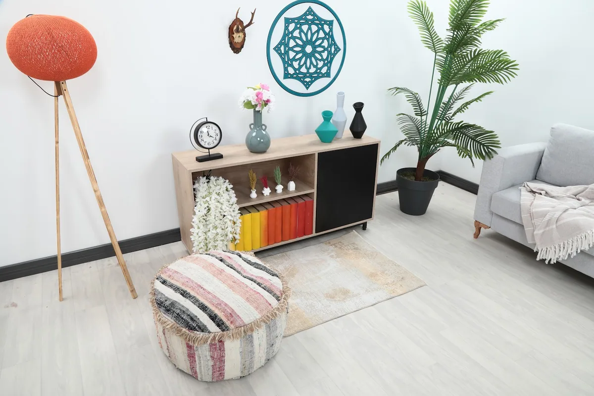 Angle view of the rug in a living room with a gray sofa, media console, and decorative items.
