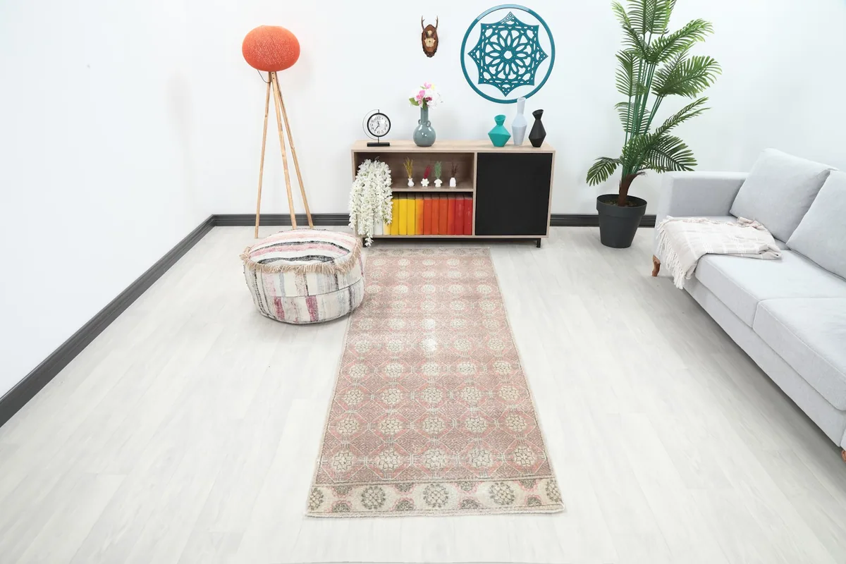 Vintage Anatolian runner rug displayed in a modern living room setting with a sofa and decor.