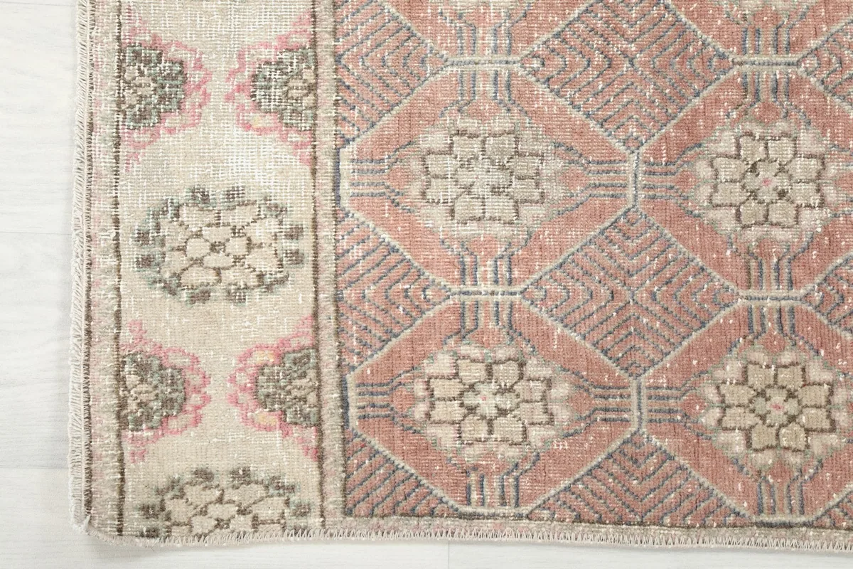 Detailed view of the rug's border design and field pattern where colors transition.