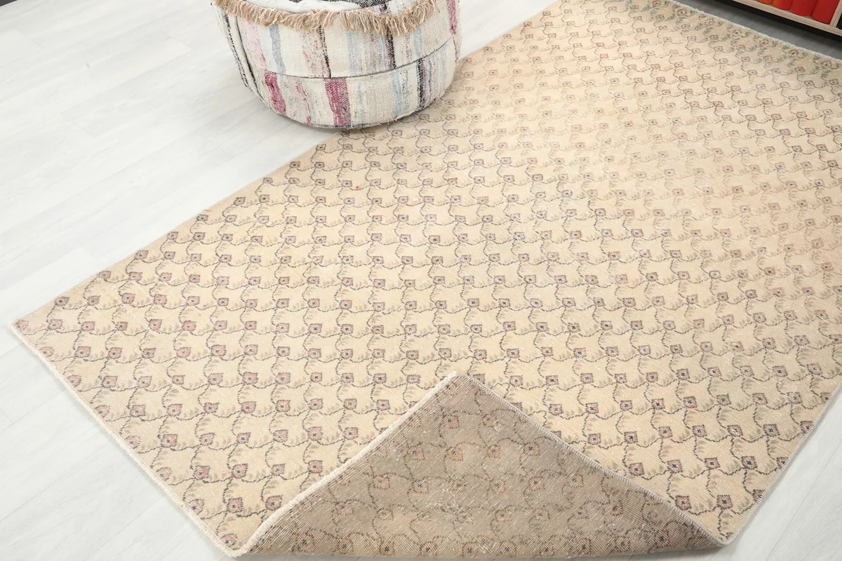 View of the rug's underside, revealing the hand-knotted cotton foundation and wool pile construction.