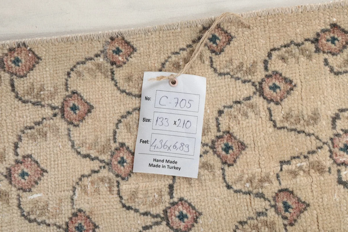 Close-up of the rug's surface with an identification tag showing its dimensions and origin.
