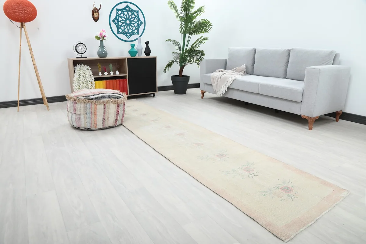 Angle view of the cream runner rug in a living space, highlighting its length and floral design.
