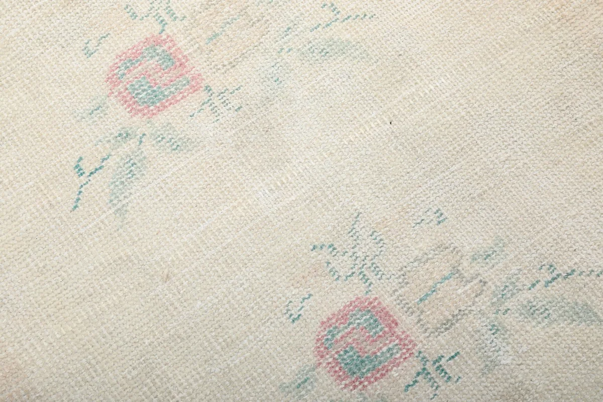 Macro detail of the hand-knotted wool pile, showing individual knots and subtle color variations in the motifs.