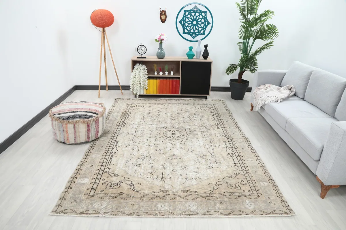 Vintage ivory and beige rug displayed in a modern living room setting with a gray sofa.