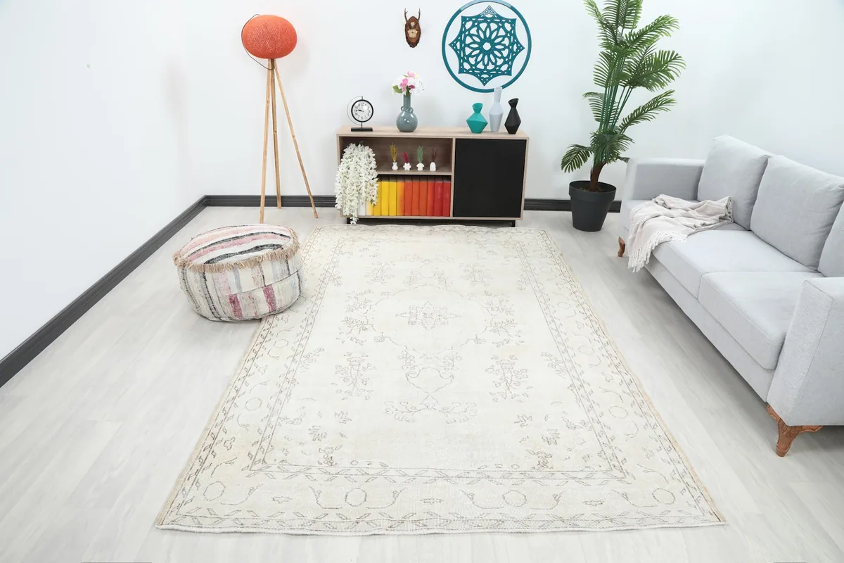 Vintage ivory rug in a modern living room setting, showing its scale with a sofa and decor