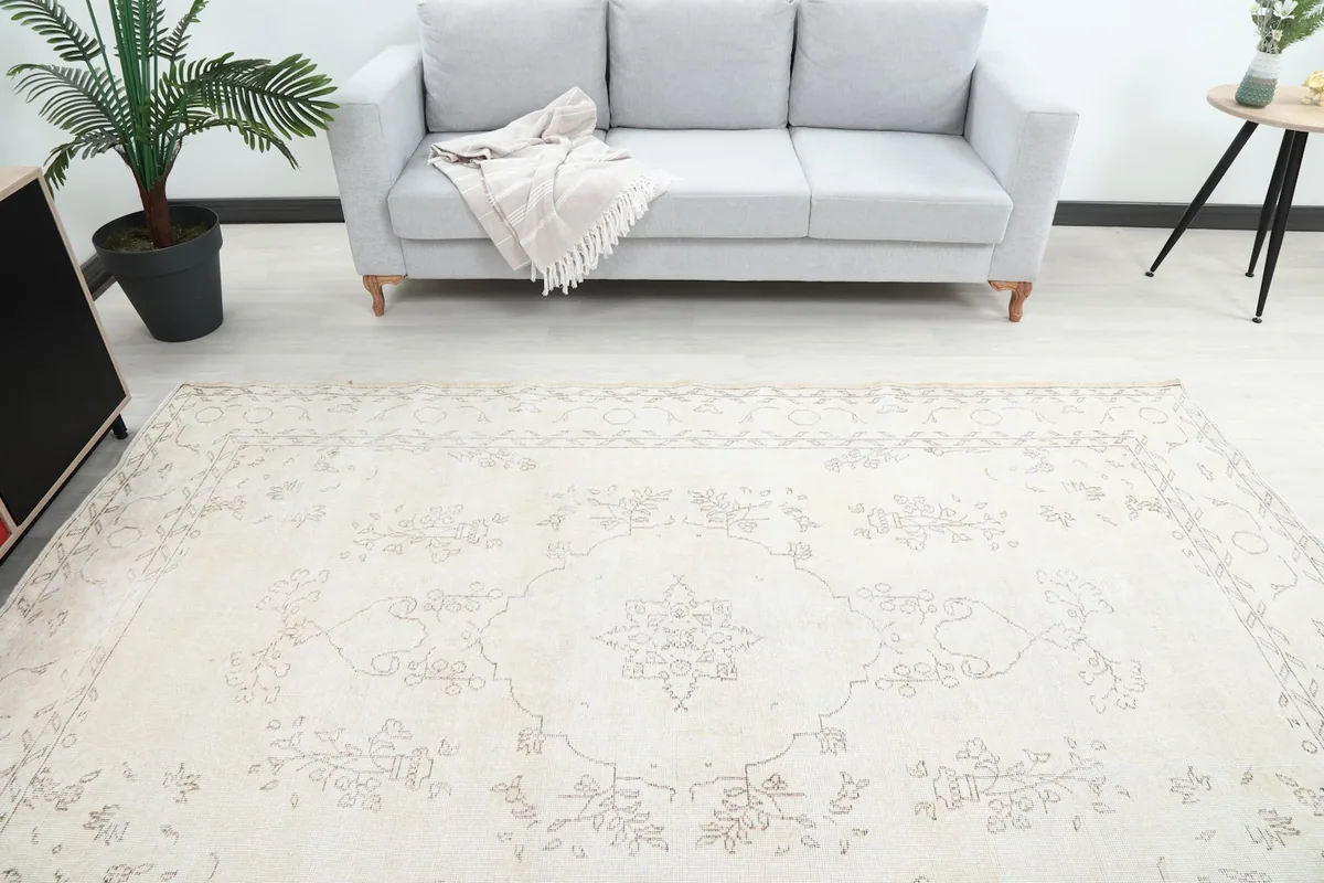 Overhead shot of the ivory rug in a room, emphasizing its full pattern layout and dimensions
