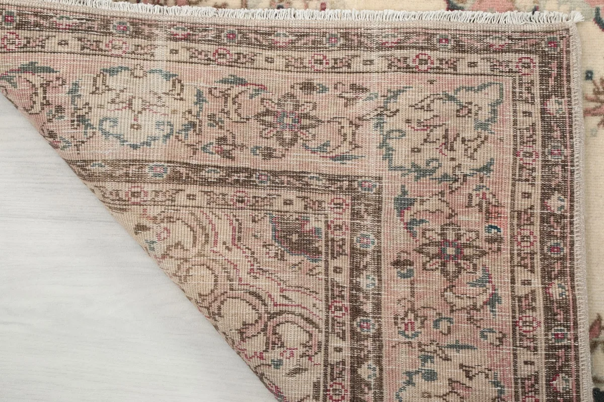 Underside of the rug's corner, revealing the hand-knotted cotton foundation