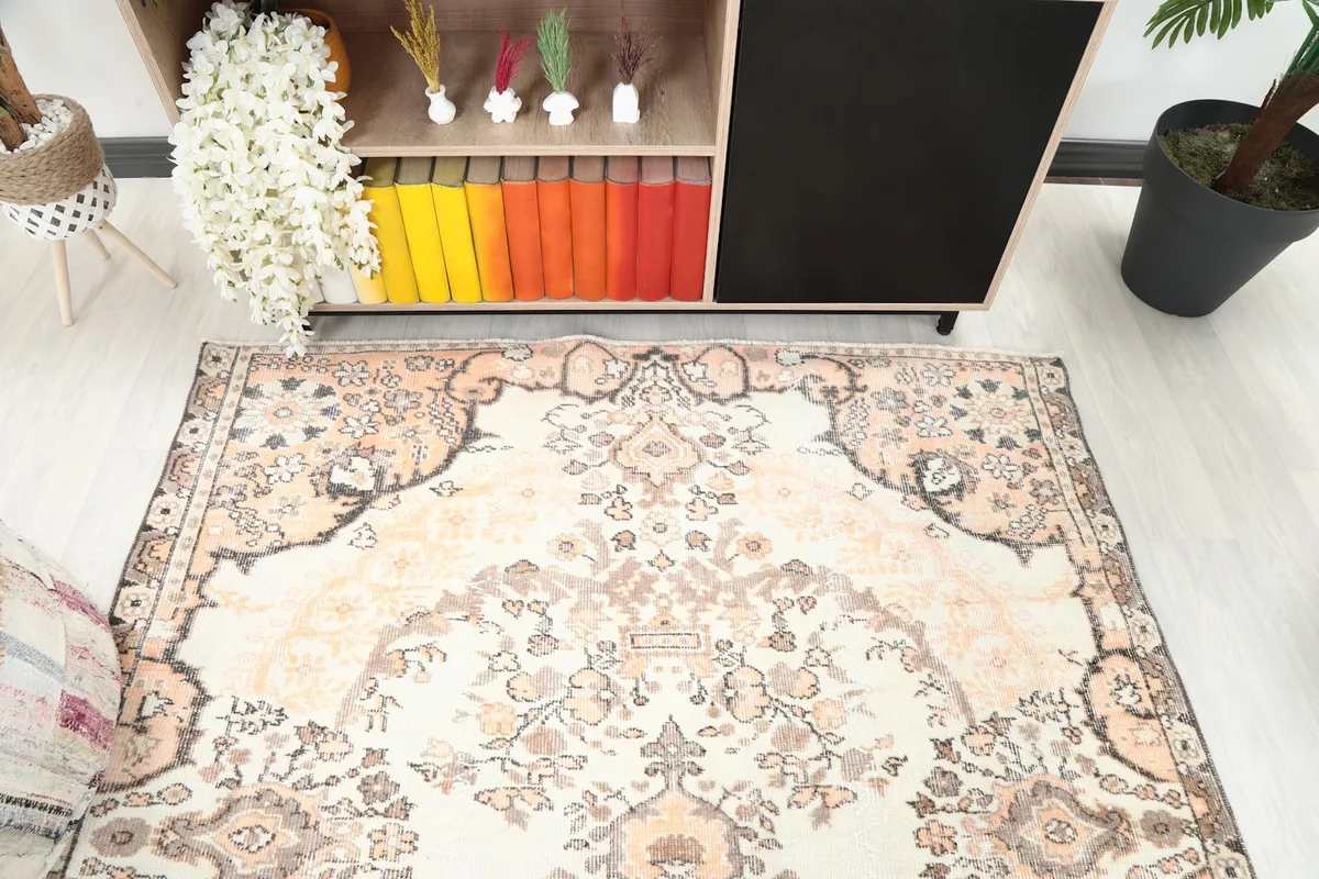 Angled view from above, showing the rug's floral motifs and ivory field