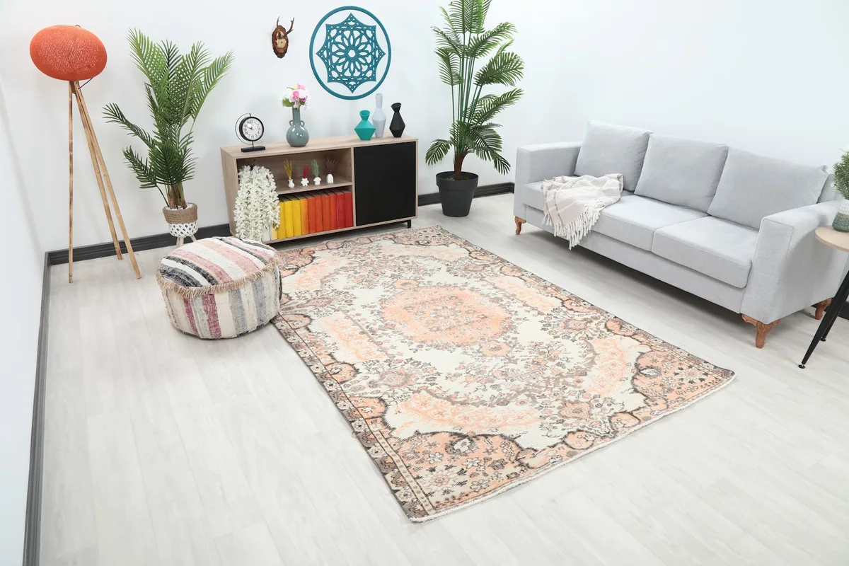 Angle view of the ivory and orange rug in a room, highlighting its placement