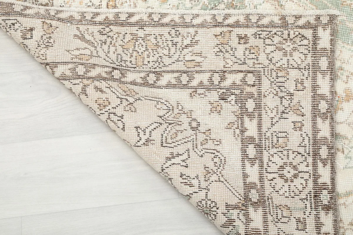 Detailed view of the rug's folded corner, highlighting the hand-knotted wool pile and cotton foundation