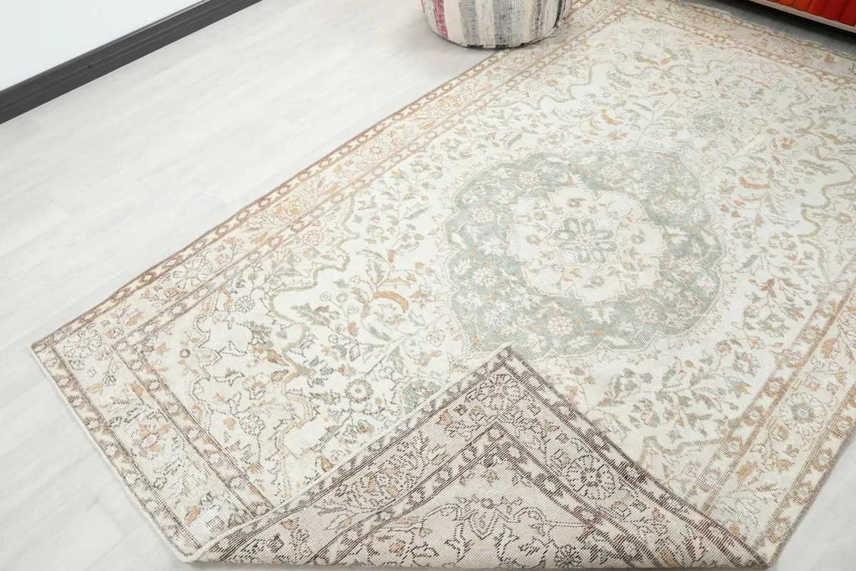 View of the rug with a corner folded back, showing the back of the hand-knotted construction