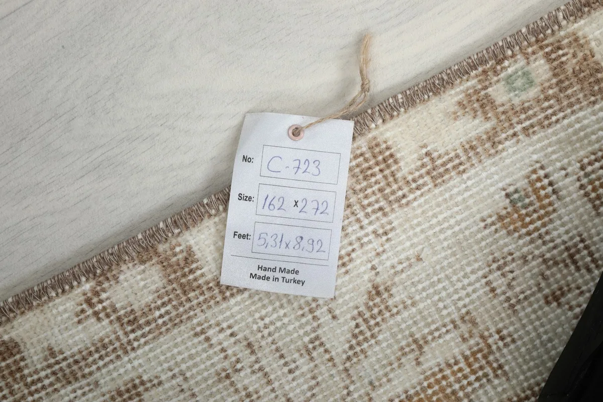 Tag showing the rug's dimensions in centimeters and feet, confirming hand-made origin in Turkey
