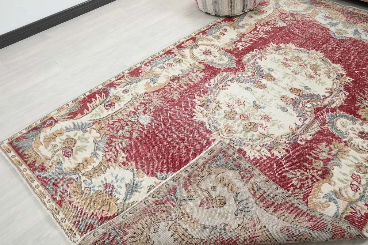 Corner of the rug folded back, revealing the hand-knotted wool pile and cotton foundation.