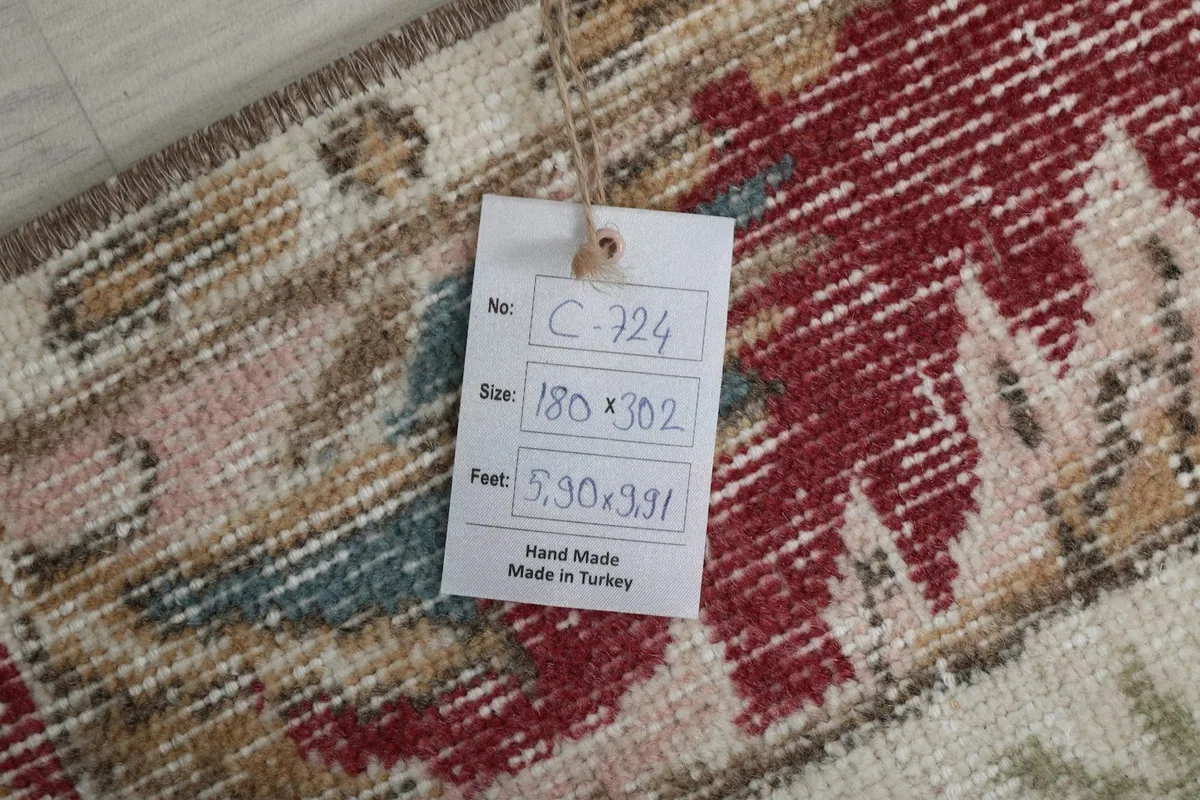 Tag attached to the rug displaying its size in centimeters and feet, and origin.