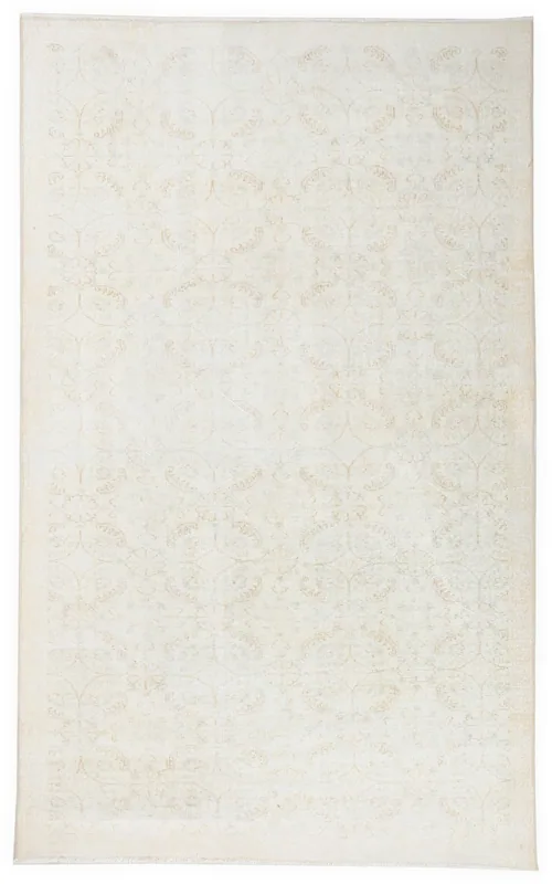 Full top view of the 5'9" x 9'5" ivory and beige vintage Anatolian area rug with subtle floral and medallion patterns.
